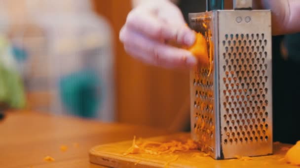 Manos de mujer frotando zanahorias en rallador en una cocina casera. Moción lenta — Vídeos de Stock