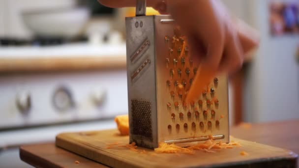 Femme mains frotter des carottes sur la râpe dans une cuisine maison. Mouvement lent — Video