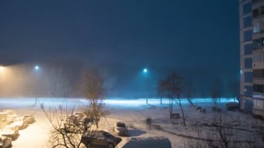 Kar bir elektrik direği arka planı sokakta geceleri düşüyor. Zaman atlamalı