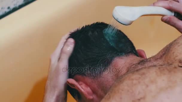 Joven se lava la cabeza bajo la ducha . — Vídeo de stock