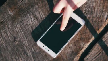 Smartphone ahşap arka plan üzerinde parmak hareketleri kız yönetir