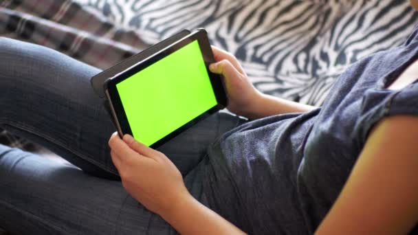 女孩躺在床上和在家里用绿色屏幕平板电脑. — 图库视频影像