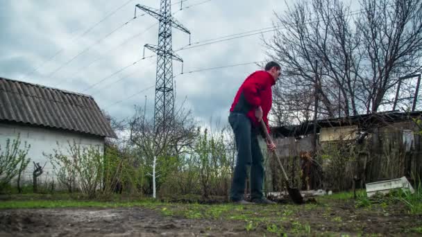Молодой фермер копает землю со старой грязной лопатой в саду. Время покажет — стоковое видео