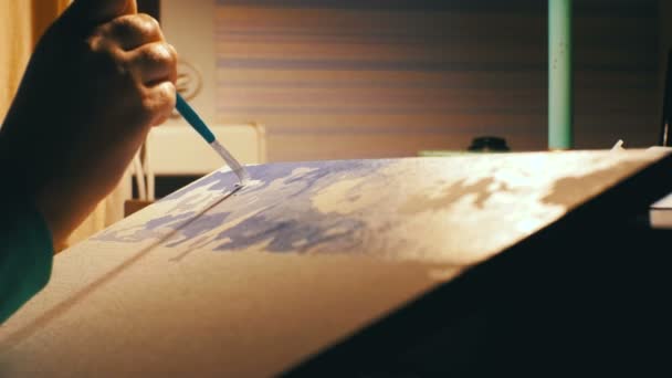 Une artiste assise à une table dessine une image à la maison — Video