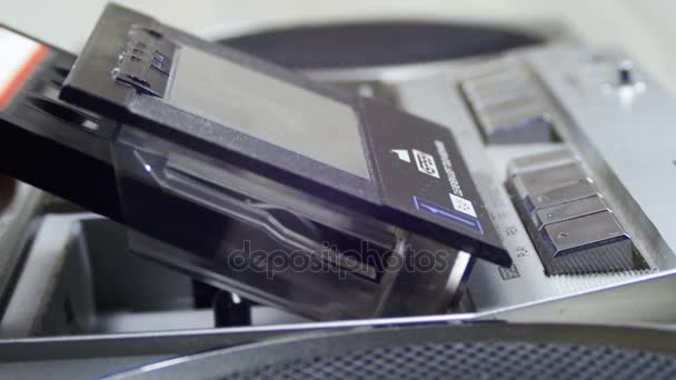 Abrindo a plataforma de cassetes, inserindo uma fita cassete e tocando um gravador — Vídeo de Stock
