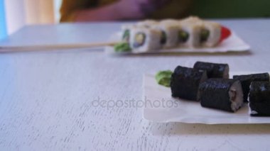 Beyaz şık ahşap masa Nori bir Japon restoranı ile suşi rulo levha. Dolly atış