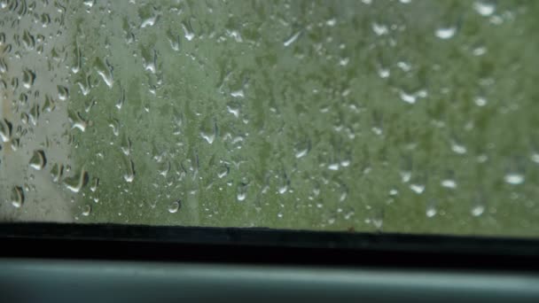 Gotas de lluvia en la ventana y lluvia detrás de la ventana de plástico — Vídeo de stock