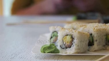 Şık beyaz ahşap bir masa üzerinde bir Japon restoranında taze suşi rulo