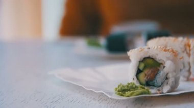 Şık beyaz ahşap bir masa üzerinde bir Japon restoranında taze suşi rulo