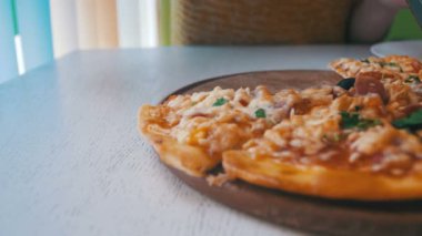 Kadın bir restoranda bir beyaz tahta masada beyaz tabakta Pizza bir dilim. Dolly atış