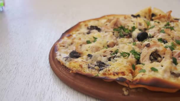 Pizza auf einem weißen Holztisch in einem Café. Kugelstoßer — Stockvideo