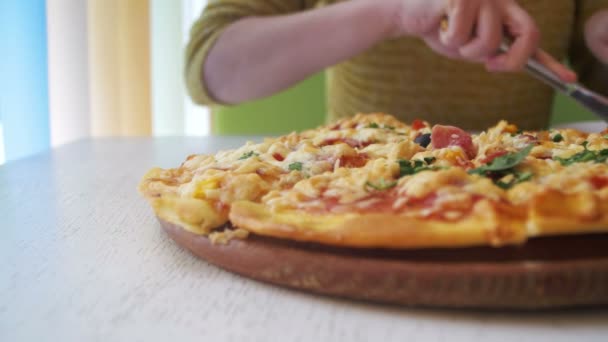 A menina está comendo uma pizza em uma placa branca em um restaurante em uma mesa de madeira branca. Dolly Shot — Vídeo de Stock