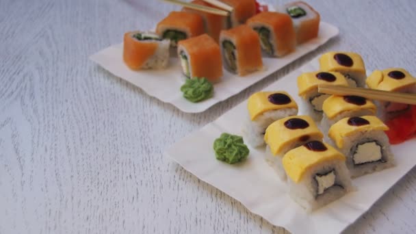 Rollos de sushi en un restaurante en una elegante mesa de madera — Vídeo de stock