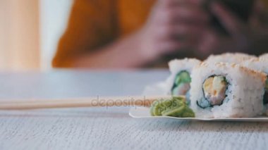 Taze Sushi plakalı bir Japon restoranı şık bir beyaz tahta masada alır. Dolly atış
