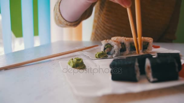 Ätpinnar med Sushi rulle med Nori från en platta på en japansk restaurang — Stockvideo