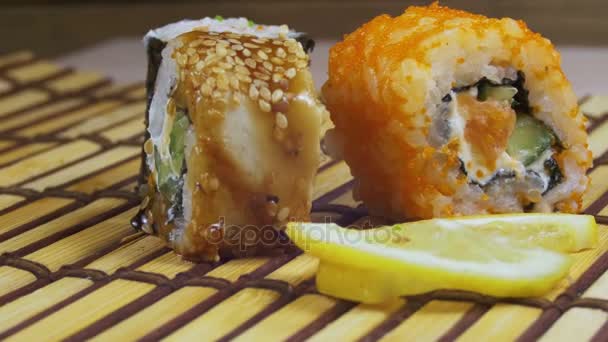 Rotoli di sushi su un tappetino di bambù ruota — Video Stock