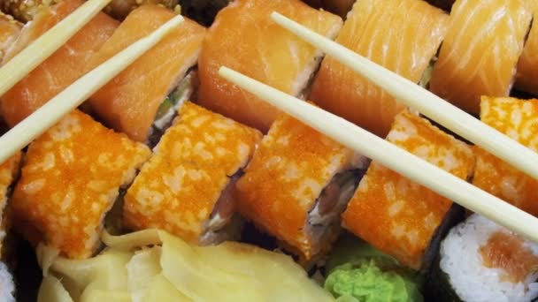 Japansk Sushi rullar med ätpinnar roterar — Stockvideo
