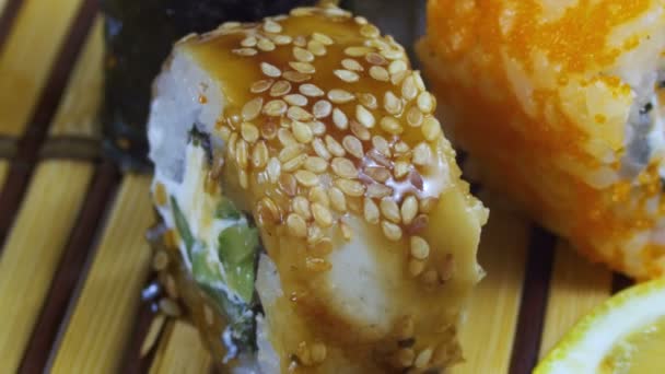 Sushi Rolls em um tapete de bambu gira — Vídeo de Stock