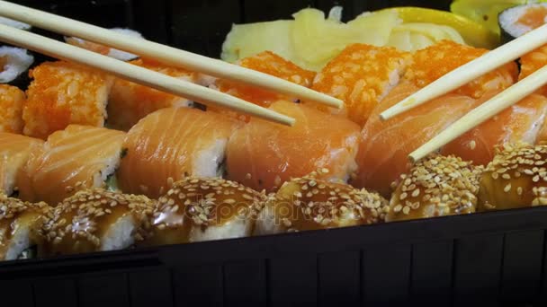 Japansk Sushi rullar med ätpinnar roterar — Stockvideo