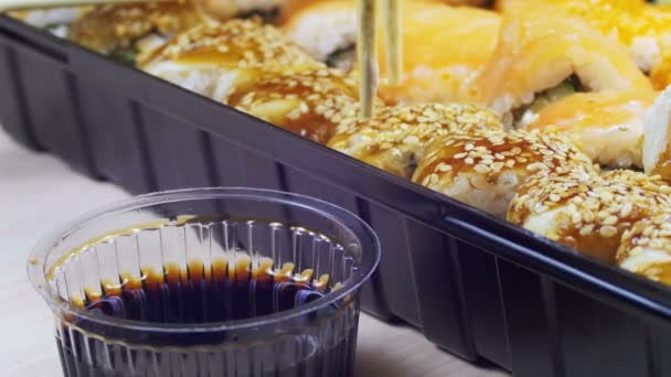 Stäbchen mit Sushi-Rolle und Dip in Sojasauce. — Stockvideo