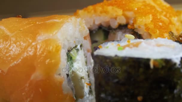 Rotoli di sushi su un tappetino di bambù ruota — Video Stock