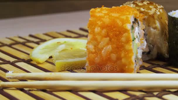 Sushi Rolls em um tapete de bambu gira — Vídeo de Stock