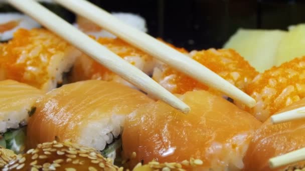 Japanische Sushi-Rollen mit Stäbchen rotieren — Stockvideo