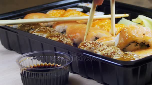 Baguettes prenant le rouleau de sushi et tremper dans la sauce soja . — Video