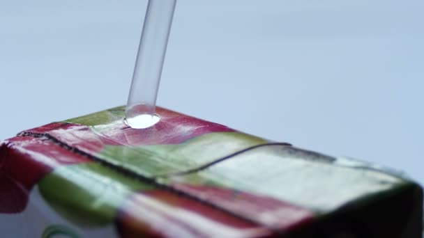 Dricka saft från ett papper paket genom ett sugrör — Stockvideo
