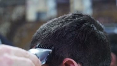 Kuaför evde clipper ile genç insan saçı keser