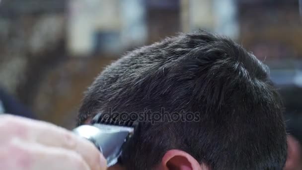 Parrucchiere taglia i capelli di un giovane con Clipper a casa — Video Stock