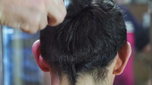 Friseur schneidet einem jungen Mann zu Hause mit Haarschneidemaschine die Haare — Stockvideo