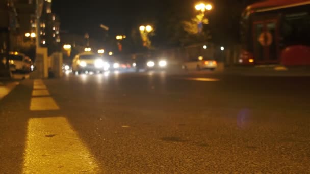 Éjszakai forgalom a városban. Defocused autók hajt a fények éjszaka úton. — Stock videók