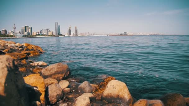 Töltés, Baku, Azerbajdzsán. A Kaszpi-tenger, a kövek és a felhőkarcolók. Lassú mozgás — Stock videók
