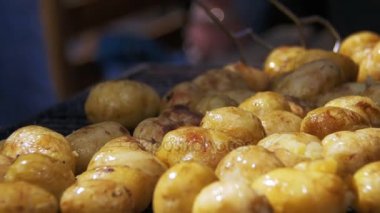Genç patatesler ızgarada hazır olsun. Barbeküde patates döndürmek için maşa kullanıyorum.