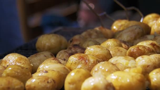 As batatas jovens preparam-se em uma grelha. Mão usando pinças para virar batatas no churrasco — Vídeo de Stock