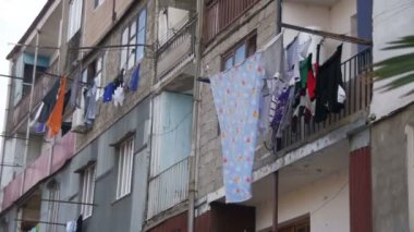 Giysi tartmak ve şehrin yoksul bir mahallede bir çok katlı binada bir ip üzerinde kuru. Ağır çekim
