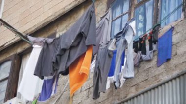 Giysi tartmak ve şehrin yoksul bir mahallede bir çok katlı binada bir ip üzerinde kuru. Ağır çekim