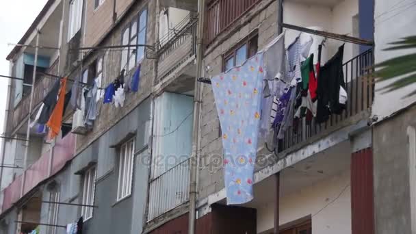 La ropa pesa y se seca con una cuerda en un edificio de varios pisos en un barrio pobre de la ciudad. Moción lenta — Vídeos de Stock