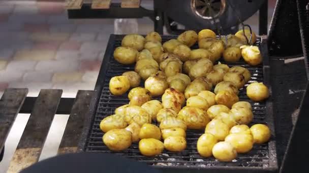 Genç patatesler ızgarada hazır olsun. Barbeküde patates döndürmek için maşa kullanıyorum. — Stok video