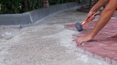 Taş döşeme kaplama Hammer kullanarak çalışıyor