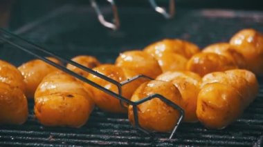 Yavaş çekimde bir ızgarada genç patates hazırlamak