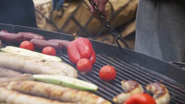 准备烧烤好吃的香肠和蔬菜在烤架上。慢动作 — 图库视频影像