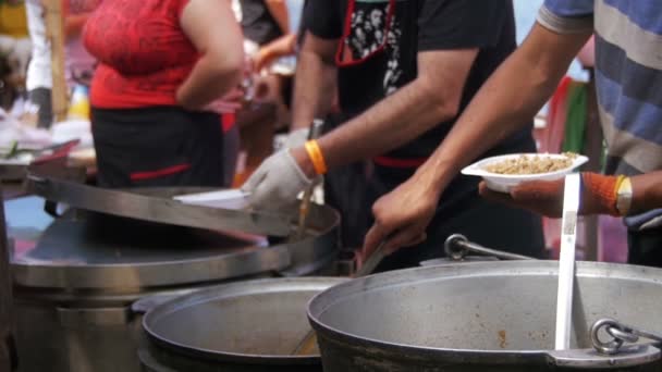 As pessoas vendem alimentos prontos para comer no mercado de rua na festa de churrasco. Movimento lento — Vídeo de Stock