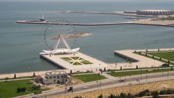 Vista panorámica de la rueda de la fortuna gira cerca del mar, el tráfico de coches en la carretera. Bakú, Azerbaiyán. Tiempo de caducidad — Vídeo de stock