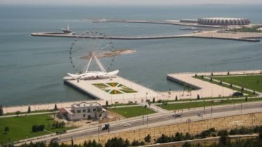 Dönme dolap panoramik manzaralı denize sıfır, yolda araçların trafik döner. Bakü, Azerbaycan. Zaman atlamalı