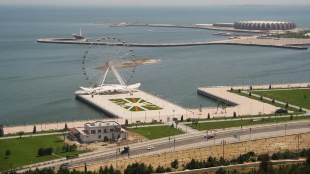 Vista panorâmica da roda gigante gira perto do mar, o tráfego de carros na estrada. Baku, Azerbaijão. Tempo de Caducidade — Vídeo de Stock