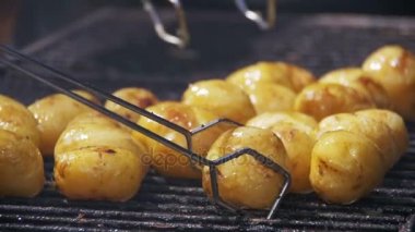 Yavaş çekimde bir ızgarada genç patates hazırlamak