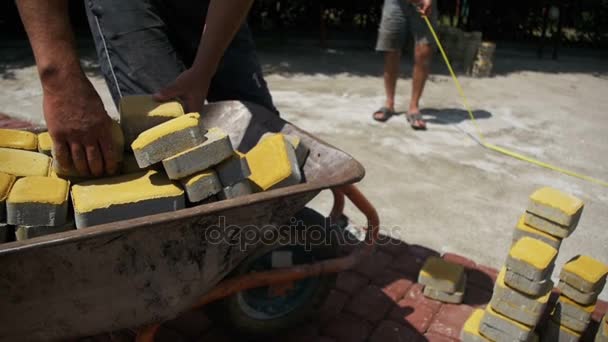 Construction Site, the Construction Worker Unloads the Stone Paving from the wheelbarrow. Slow Motion — Stock Footage Construction Site, the Construction Worker Unloads the Stone Paving from the wheelbarrow. Slow Motion Royalty Free Stock Video