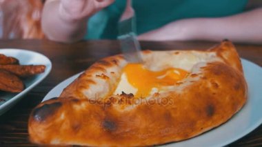 Acara Khachapuri bir çatal ile ahşap bir masa üzerinde bir Gürcü restoranda yemek kadın. Gürcü gıda
